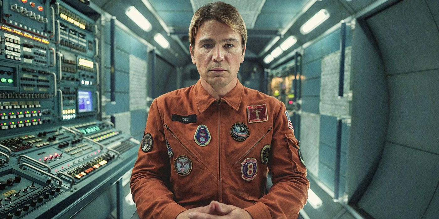 David sitting on the spaceship, staring into space in a scene from Black Mirror, Beyond the Sea