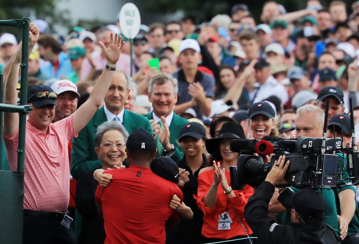 Tiger hugs his children, with his mom, Tida, over his left shoulder.