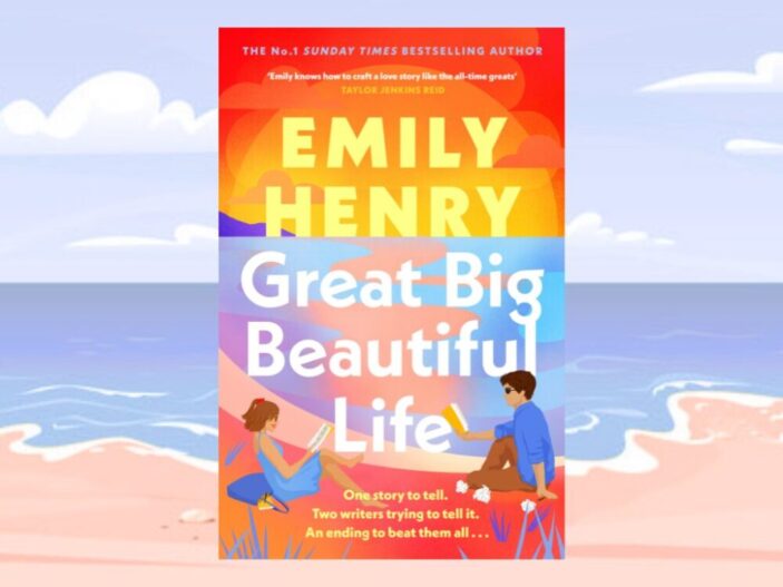 Great Big Beautiful Life is a romance novel with a colourful cartoon cover featuring a man and a woman writing on a beach on opposite sides of the title. It is predominately orange and purple and blue. 