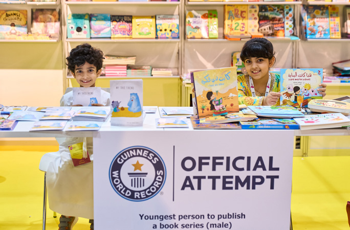two siblings signing their books